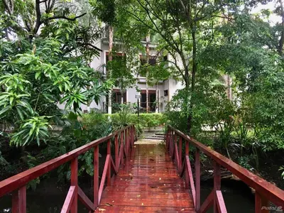 a wooden bridge in front of a building at Macaws Ocean Club Apartamento # 18 in Jacó