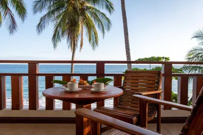 a table and chairs on a balcony with the ocean at Tango Mar Beachfront Boutique Hotel & Villas in Tambor