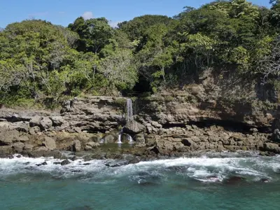 a waterfall on the side of a rocky beach at Tango Mar Beachfront Boutique Hotel & Villas in Tambor