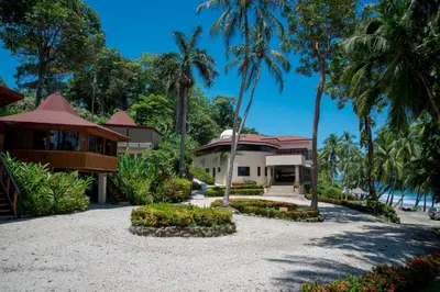 a house on the beach with palm trees at Tango Mar Beachfront Boutique Hotel & Villas in Tambor