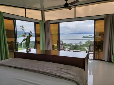 a bedroom with a bed and a large window at Hotel Laguna Arenal in Unión