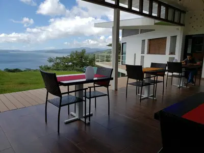 a table and chairs on a patio with a view at Hotel Laguna Arenal in Unión