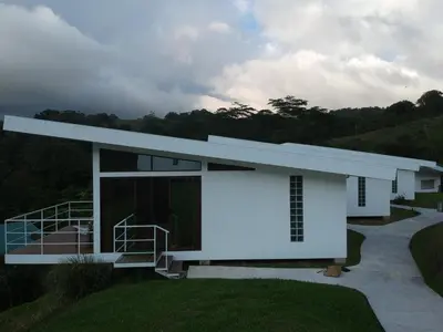 a white house with a staircase in front at Hotel Laguna Arenal in Unión