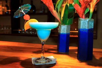 a martini glass sitting on a table with two blue vases at Tenorio Lodge in Bijagua