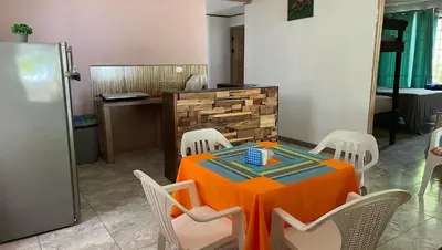 a dining room with a table with chairs and a refrigerator at Casa turtle Bogue in Tortuguero
