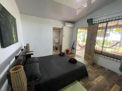 a bedroom with a bed and a door to a bathroom at Casa turtle Bogue in Tortuguero