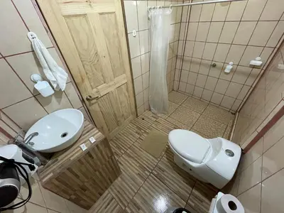 a small bathroom with a toilet and a sink at Casa turtle Bogue in Tortuguero