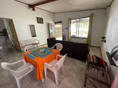 a dining room with an orange table and chairs at Casa turtle Bogue in Tortuguero