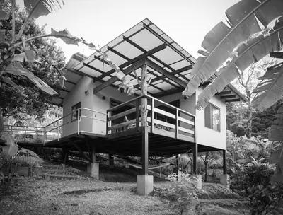 a house with a balcony on the side of it at Aves de Tierras Altas in Bijagua