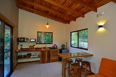 a kitchen with a table and chairs and a counter at Aves de Tierras Altas in Bijagua