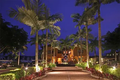 a pathway with palm trees in front of a building at HRG Condos at Los Sueños in Jacó