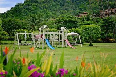 a playground with two swings in a park at HRG Condos at Los Sueños in Jacó