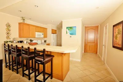 a kitchen with a bar with stools in it at HRG Condos at Los Sueños in Jacó