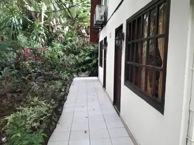 a walkway outside of a house with plants at Hotel La Colina in Manuel Antonio