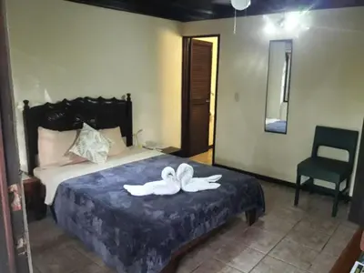 a bedroom with a bed with a white towel on it at Hotel La Colina in Manuel Antonio