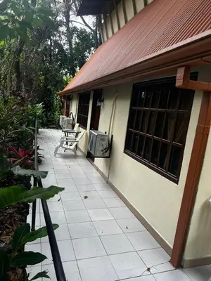 a porch of a house with a tv on it at Hotel La Colina in Manuel Antonio