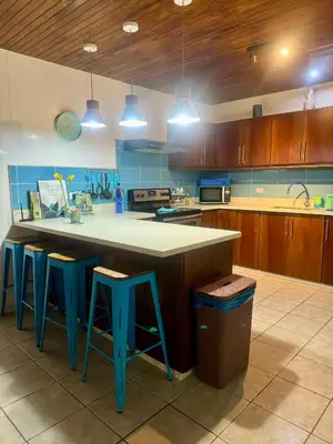 a kitchen with a large island with blue stools at La Buena Vida 2 in Tamarindo