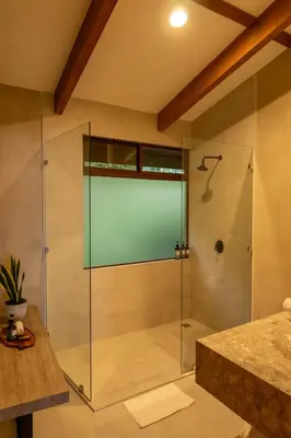 a shower with a glass door in a bathroom at Koora Monteverde a Cloud Forest Hotel by Sandglass in Monteverde Costa Rica
