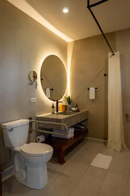 a bathroom with a toilet and a sink with a mirror at Koora Monteverde a Cloud Forest Hotel by Sandglass in Monteverde Costa Rica