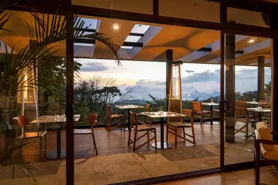 a restaurant with tables and chairs on a balcony at Koora Monteverde a Cloud Forest Hotel by Sandglass in Monteverde Costa Rica