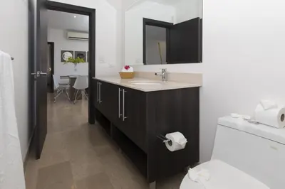 a bathroom with a sink and a toilet at Modern 2BR Condo Partial Ocean View - Roble Sabana - Reserva Conchal Golf Resort in Playa Conchal