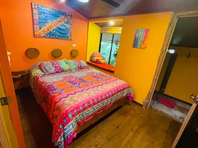 a bedroom with a bed in a yellow room at El Sol Monteverde in Monteverde Costa Rica