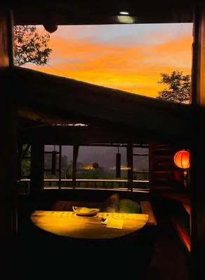 a bed in a room with a sunset in the background at El Sol Monteverde in Monteverde Costa Rica