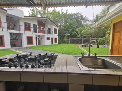 a kitchen with a stove top oven next to a yard at Hotel Vive Uvita in Uvita