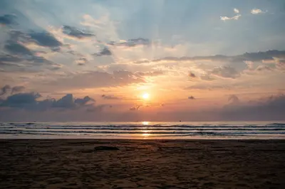 a sunset on a beach with the ocean at Hotel Vive Uvita in Uvita