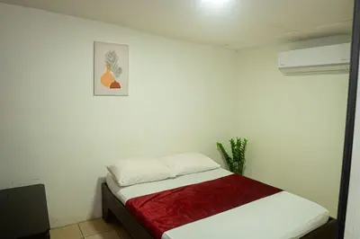a bedroom with a bed with a red blanket at Hotel Vive Uvita in Uvita