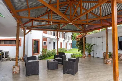 an outdoor patio with chairs and a large wooden structure at Hotel Vive Uvita in Uvita