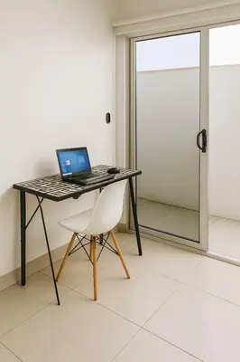 a laptop computer sitting on a table with a chair at Costa Rica, San José, Pinares Luxe Apt Near Elite Clinics in San José