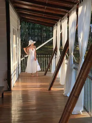 a little girl in a white dress walking down a porch at Ballena Dorada Lodge in Uvita