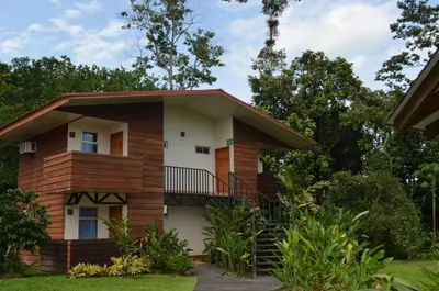 a house with a staircase in front of it at Hotel Eco Arenal in Fortuna