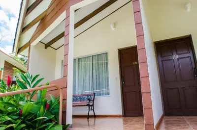 a house with two doors and a chair at Hotel Eco Arenal in Fortuna