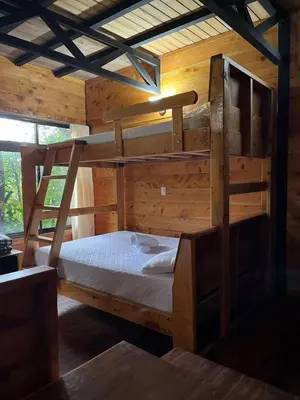 a bedroom with two bunk beds in a cabin at Cabañas el Bosque in Turrialba