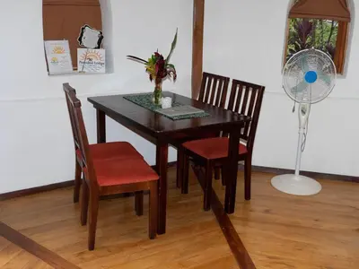 a dining room table with two chairs and a fan at Casa Romantica in Platanillo