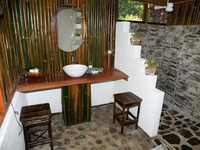 a bathroom with a sink and a mirror and two stools at Casa Romantica in Platanillo