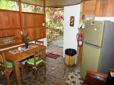 a dining room with a table and a refrigerator at Casa Romantica in Platanillo