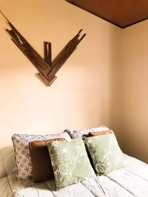 a shelf on the wall above a bed with pillows at Cabaña Vista Verde in Cartago