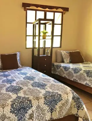 a bedroom with two beds and a window at Cabaña Vista Verde in Cartago