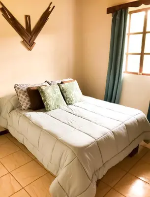 a large white bed in a room with a window at Cabaña Vista Verde in Cartago