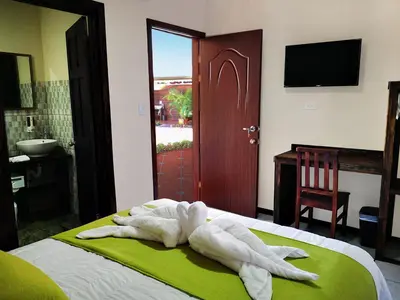a towel animal laying on top of a bed at Hotel Amaranto in San Ramón