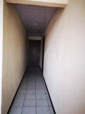 an empty hallway with a door and a tile floor at Hotel Amaranto in San Ramón
