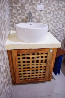 a bathroom with a white sink on a wooden vanity at Casa Nelly Apartamentos in Sámara
