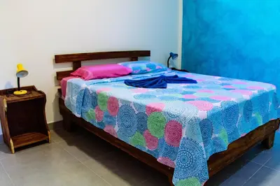a bedroom with a bed with a colorful comforter at Casa Nelly Apartamentos in Sámara