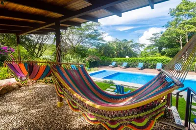 a hammock in front of a swimming pool at Rinconcito Lodge in Liberia