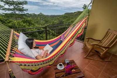 a woman laying in a hammock reading a book at Rinconcito Lodge in Liberia