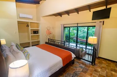 a bedroom with a bed and a large window at Rinconcito Lodge in Liberia