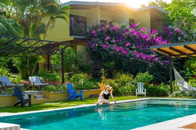 a woman in a bikini sitting in a swimming pool at Rinconcito Lodge in Liberia